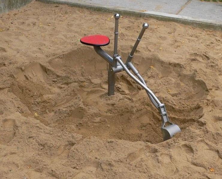 A toy excavator machine in a playground sandbox.